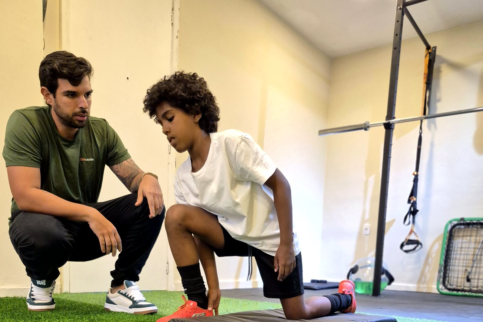 Fisioterapeuta da ION saúde orientando jovem atleta em exercício